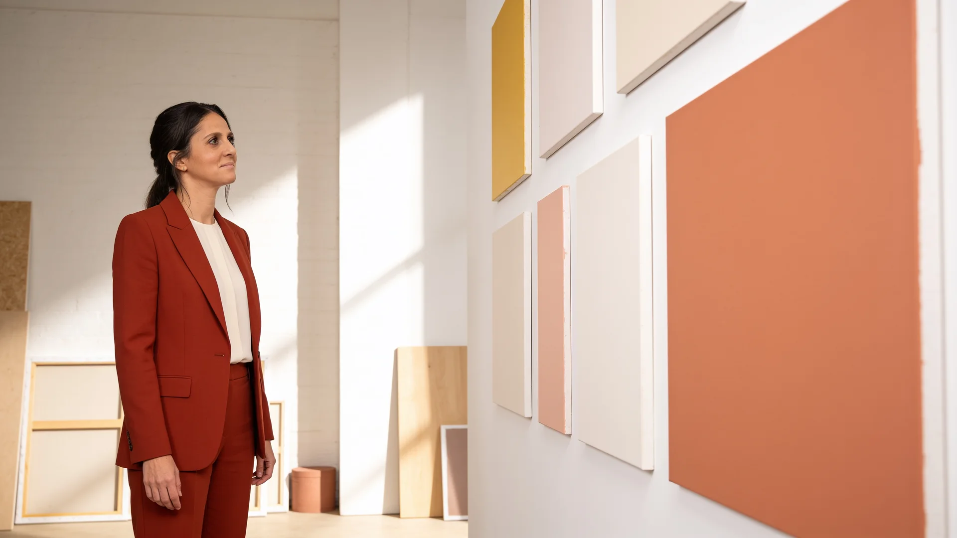 Baha Meier-Arian betrachtet Arbeiten in einem hellen Atelier zum Thema Perfektionismus im Job